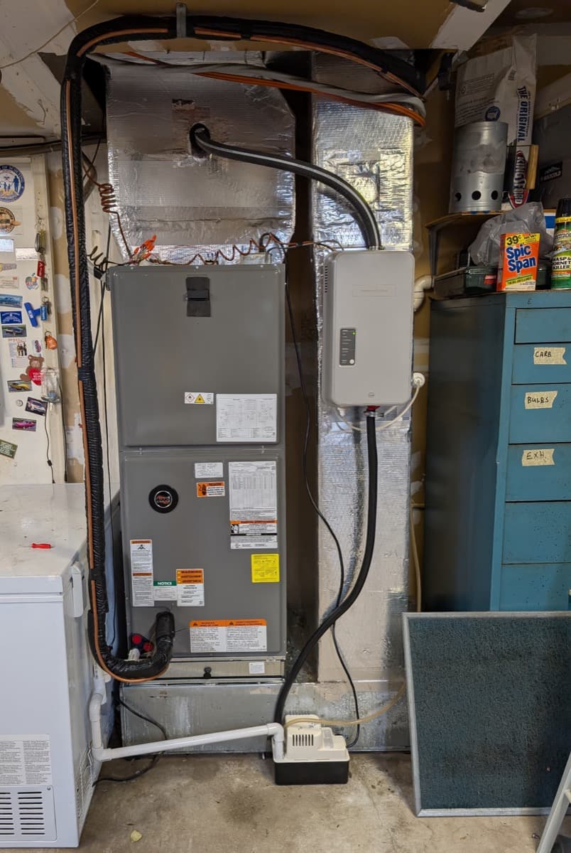 Furnace and tankless water heater installed side by side in a garage utility room