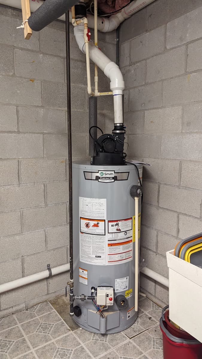 Commercial-grade gas water heater installed in a basement corner